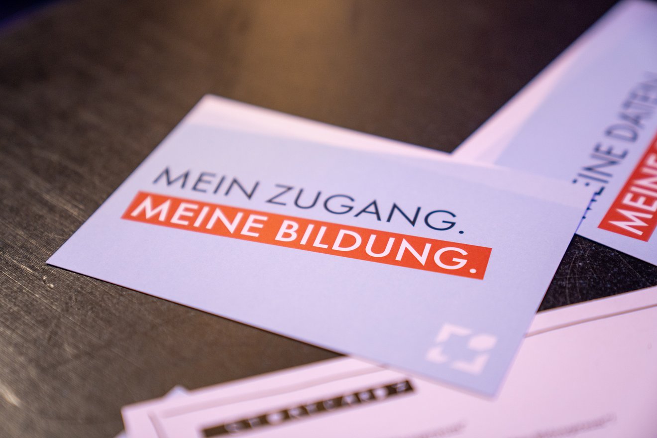 Postkarte mit Text "Mein Zugang. Meine Bildung." auf einem Tisch